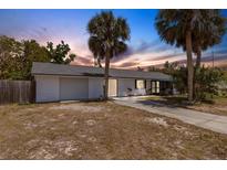 Charming single-story home with a one car garage and lush palm trees in the front yard at 112 E Marland Ct, Nokomis, FL 34275
