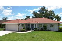 Charming single-story home featuring a beautiful tile roof, well-manicured lawn, and lush landscaping at 1654 Waxwing Ct, Venice, FL 34293