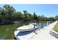 View of private boat dock and serene canal on a sunny day with lush greenery surrounding the waterway at 2124 N Tamiami Trl # 108, Sarasota, FL 34234
