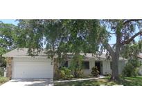 Charming single-story home with attached garage, mature trees, and well-maintained landscaping at 2475 Wood Oak Dr, Sarasota, FL 34232