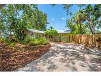 Charming single-story home with a brick walkway, lush landscaping and a well-manicured front yard at 2630 Bucida Dr, Sarasota, FL 34232