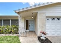Charming entryway with decorative door, well-maintained landscaping, and attached garage at 3127 Dawson St, Sarasota, FL 34239