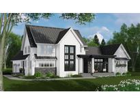 Charming two-story white home with black accents, stone detail, professional landscaping, and a covered entryway at 4704 Riverwood Ave, Sarasota, FL 34231