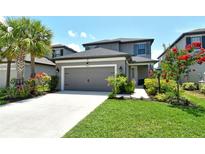 Charming two-story home with a well-manicured lawn, lovely landscaping, and an attached two-car garage at 5475 Summit Gln, Bradenton, FL 34203