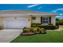 Charming single-story home featuring a well-manicured lawn, white garage door and a neatly landscaped garden at 915 Sw Barclay Ct, Venice, FL 34293