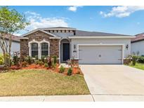 Charming single-story home with stone accents, a two-car garage, and well-maintained landscaping at 11194 Spring Point Cir, Riverview, FL 33579