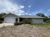 Modest single-story home with an attached garage and a lawn needing maintenance at 1036 Arden Nw Ter, Port Charlotte, FL 33948