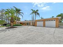 Stunning home featuring an oversized driveway, lush landscaping, and an attached two-car garage at 1203 Lyric Ln, Sarasota, FL 34242