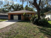 Charming single-story home showcasing a manicured lawn and a two car garage at 13017 Club Dr, Hudson, FL 34667