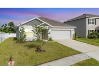 Charming single-Gathering home featuring a well-maintained lawn and an attached two-car garage at 2105 Grand Flora Trl, Bradenton, FL 34208