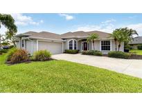 Well maintained single-story home with landscaped lawn, two-car garage, and inviting front door at 2199 Palm Ct, North Port, FL 34287