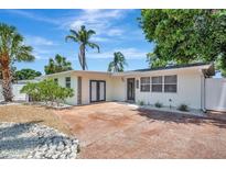 Charming single-story home featuring a well-manicured lawn, tropical landscaping, and an inviting front entry at 2363 Milford Cir, Sarasota, FL 34239