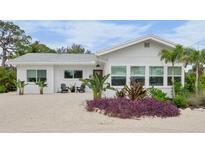 Charming single story home with a manicured front yard featuring colorful landscaping and updated windows at 404 Bayshore Rd, Nokomis, FL 34275