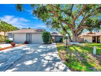 Charming single-story home featuring a spacious two-car garage and a lush, mature tree in the front yard at 5192 Cedar Hammock Ln, Sarasota, FL 34232