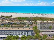 Expansive beach view from a condo, with turquoise water, white sand, and a clear, sunny sky at 5600 Beach Way Dr # 201, Sarasota, FL 34242