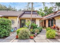 Charming home exterior with lush landscaping, potted plants, and a decorative sun at 7915 4Th W Ave # 7915, Bradenton, FL 34209
