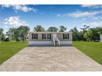 Charming home with a gravel driveway, well maintained lawn, and freshly painted siding at 8426 Sweden Blvd, Punta Gorda, FL 33982