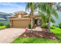Inviting home featuring a two-car garage, mature landscaping, and a paver walkway to the covered front entry at 8437 Nandina Dr, Sarasota, FL 34240