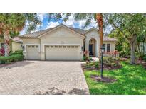 Charming single-story home featuring a three-car garage and beautifully landscaped front yard with mature trees at 12710 Stone Ridge Pl, Lakewood Ranch, FL 34202