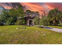 Charming single-story home featuring lush landscaping and a welcoming arched entryway at 1862 Rita St, Sarasota, FL 34231