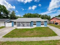 Charming blue single-story home with a well-maintained lawn and a lovely screened-in front porch at 2214 Elise Marie Dr, Seffner, FL 33584