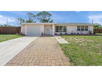 Charming single-story home featuring a well-maintained lawn and inviting brick walkway at 2524 Tuttle Way, Sarasota, FL 34239