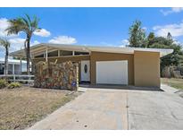 Charming single-story home features a unique stone accent wall, garage and a well-maintained yard at 2820 Greenbriar St, Sarasota, FL 34237