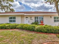 Charming single-story home featuring a well-manicured lawn and mature landscaping at 3328 Kingswood Dr, Sarasota, FL 34232
