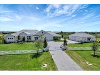Stunning white home with lush green lawn, white picket fence, and a long driveway at 3574 Recurve Cir, Sarasota, FL 34240