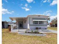 Charming single-story home featuring a covered porch, well-maintained lawn, and attractive landscaping at 5213 Bel Air Ave, Sarasota, FL 34234