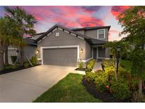 Charming two-story home with gray siding, landscaped yard, and a two-car garage under a beautiful colorful sunset at 5532 Summit Gln, Bradenton, FL 34203
