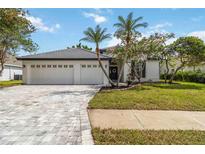 Charming home featuring lush landscaping, well-manicured lawn, and a spacious three-car garage at 6140 Bobby Jones Ct, Palmetto, FL 34221