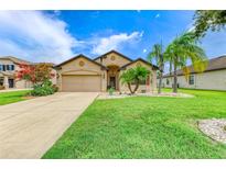 Charming one-story home boasts a well-manicured lawn, mature landscaping, and attached two-car garage at 7410 61 E St, Palmetto, FL 34221