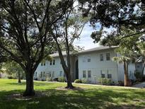 Well-maintained two-story condo building with mature trees and landscaping in a verdant community at 10800 N Us Highway 19 # 237, Pinellas Park, FL 33782