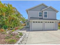 Charming two-story home features a manicured lawn, a two-car garage, and lovely landscaping at 2420 Webber St, Sarasota, FL 34239