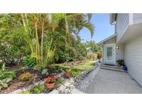 A meticulously maintained front yard with vibrant plants and flowers leads to the inviting front door at 2420 Webber St, Sarasota, FL 34239