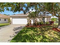 Charming single-story home featuring a well-manicured lawn, mature trees, and a two-car garage at 2662 6Th E Ct, Ellenton, FL 34222