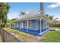 Charming blue home with a metal roof and a spacious, inviting wrap-around porch at 3320 19Th Street E Ct, Bradenton, FL 34208