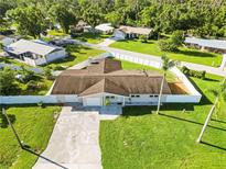 An aerial view of a single-story home featuring a well-manicured lawn and a white privacy fence at 5200 Malaga Ave, Sarasota, FL 34235