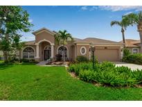 Charming single-story home featuring lush landscaping, a barrel tile roof, and an attached two-car garage at 730 Old Quarry Rd, Bradenton, FL 34212