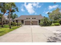 Inviting villa-style home with a private driveway and attached garage, framed by lush tropical landscaping at 7926 Woodpointe Ct # 29, Sarasota, FL 34238
