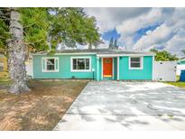 Charming teal home with a vibrant orange front door and a well-maintained front yard at 115 41St Ne Ave, St Petersburg, FL 33703