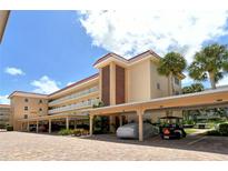 Beautiful condo complex featuring covered parking, tropical landscaping, and stunning architectural details at 1350 N Portofino Dr # 402, Sarasota, FL 34242