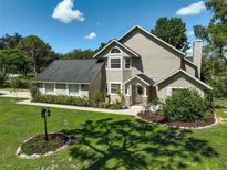Charming two-story home with a landscaped front yard and well-maintained lawn on a sunny day at 13514 4Th E Plz, Bradenton, FL 34212