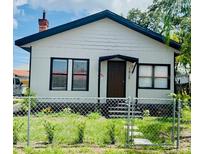 Charming home featuring a white exterior, black trim, and well-maintained front yard at 1412 12Th W Ave, Bradenton, FL 34205