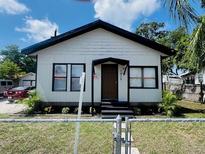 Charming single-story home with a cozy front porch and well-maintained lawn and a chain link fence at 1412 12Th W Ave, Bradenton, FL 34205