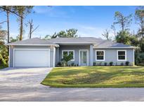 Charming single-story home with a manicured lawn, paved driveway, and an attached two-car garage at 17113 Malta Ave, Port Charlotte, FL 33954