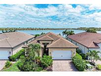 Beautiful waterfront home with lush landscaping, brick driveway, and two car garage at 204 Maraviya Blvd, Nokomis, FL 34275
