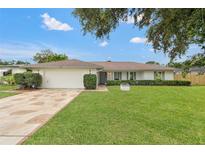 Charming single-story home featuring a manicured lawn, stone driveway, and traditional architectural details at 2430 Catalonia S Way, St Petersburg, FL 33712