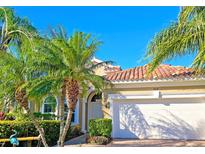 Charming home featuring lush landscaping, a red tile roof, and a two-car garage at 303 9Th E Ave, Palmetto, FL 34221